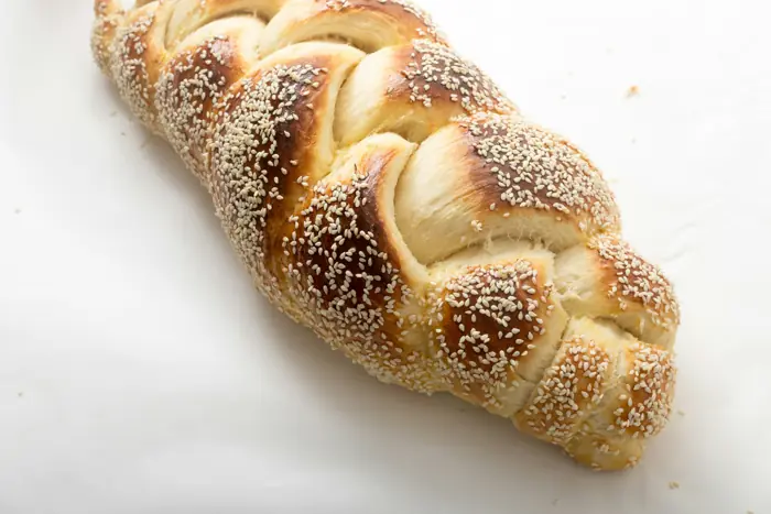 חלה קלועה עם שומשום על רקע לבן